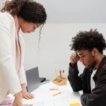 Colegas discutindo planejamento estratégico em uma mesa de escritório com expressões de concentração e preocupação.