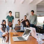 Pessoas em empresas conversando e analisando o laptop