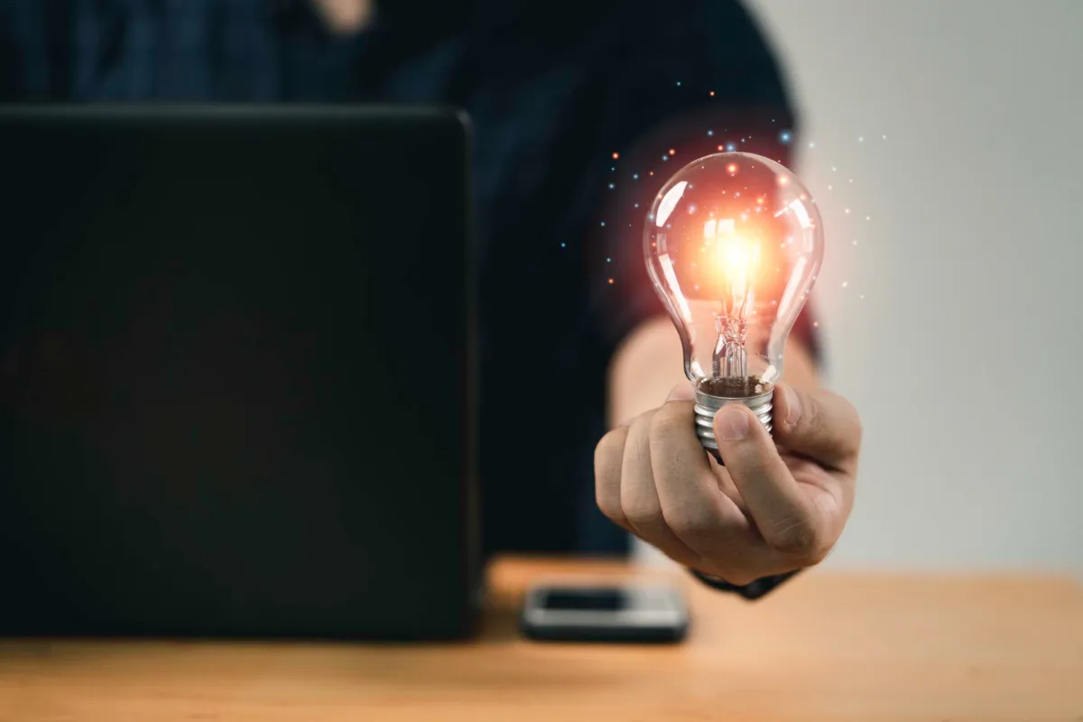 Homem segurando uma lâmpada acesa