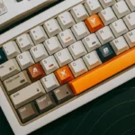 teclado compacto com teclas coloridas em destaque sobre mesa escura