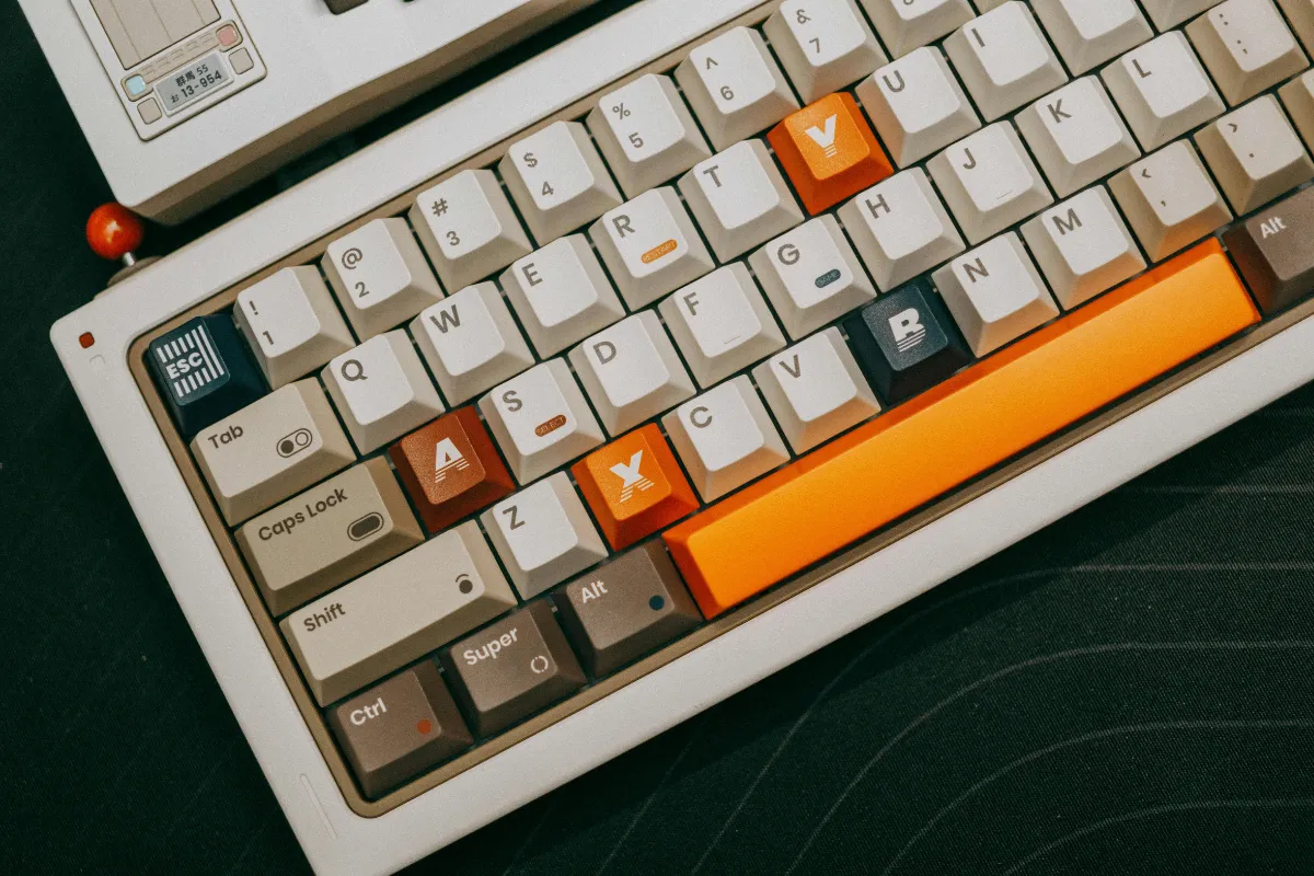 teclado compacto com teclas coloridas em destaque sobre mesa escura